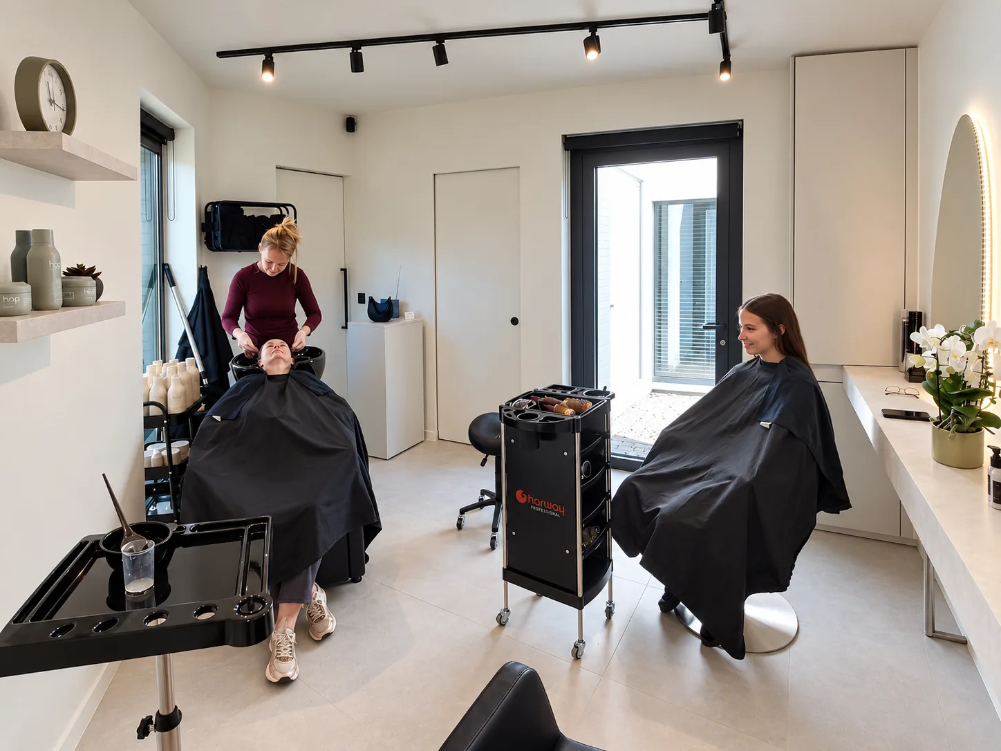 Een oma-kleindochtermomentje in het salon: Sofie wast het haar van de oma, haar kleindochter wacht in de stoel